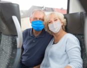 Ehepaar im Zug mit Mund-Nasen-Schutz