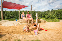 Sand spielende Kinder im Matschbereich am Badeplatz des Hammersee.