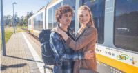 Ein Paar umarmt sich am Bahnsteig.